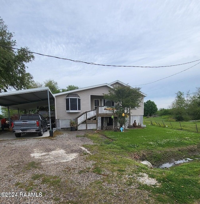 manufactured / mobile home featuring a carport and a front lawn