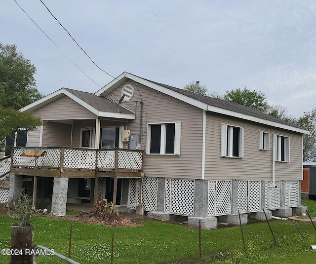 back of property with a lawn and a wooden deck