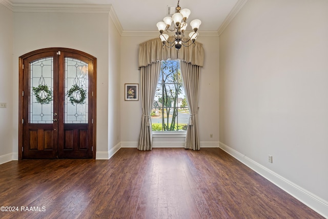 foyer with a notable chandelier, ornamental molding, dark wood-type flooring, and french doors