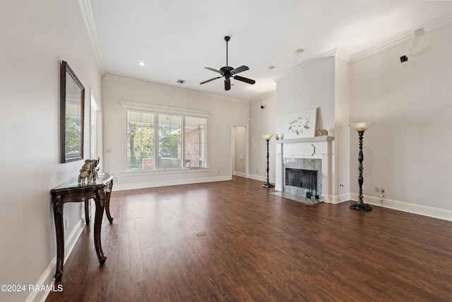 unfurnished living room with crown molding, a fireplace, ceiling fan, and dark wood-type flooring