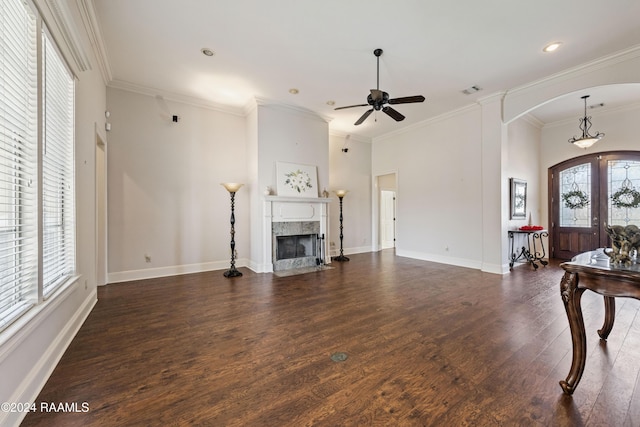 living room with ceiling fan, french doors, dark wood-type flooring, a premium fireplace, and crown molding