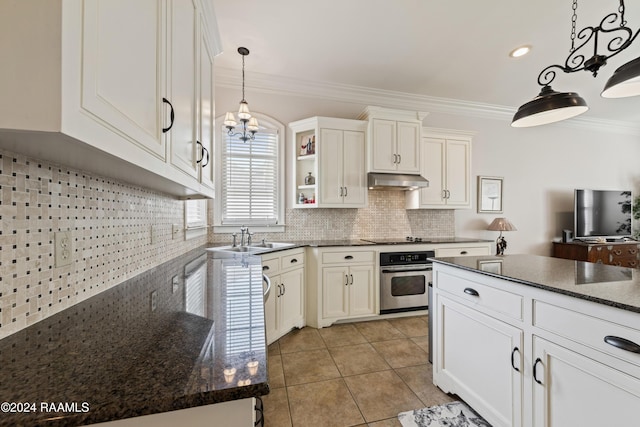 kitchen featuring exhaust hood, oven, sink, decorative backsplash, and decorative light fixtures