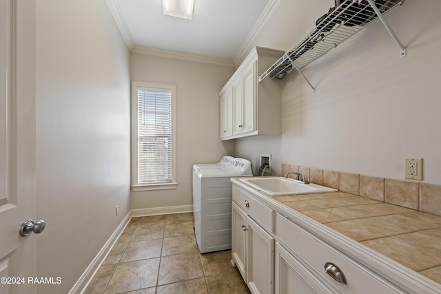 washroom featuring cabinets, ornamental molding, sink, light tile patterned floors, and independent washer and dryer