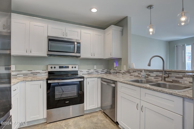 kitchen with white cabinets, sink, decorative backsplash, decorative light fixtures, and stainless steel appliances