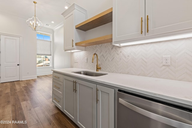 kitchen with dark wood-type flooring, sink, hanging light fixtures, stainless steel dishwasher, and ornamental molding