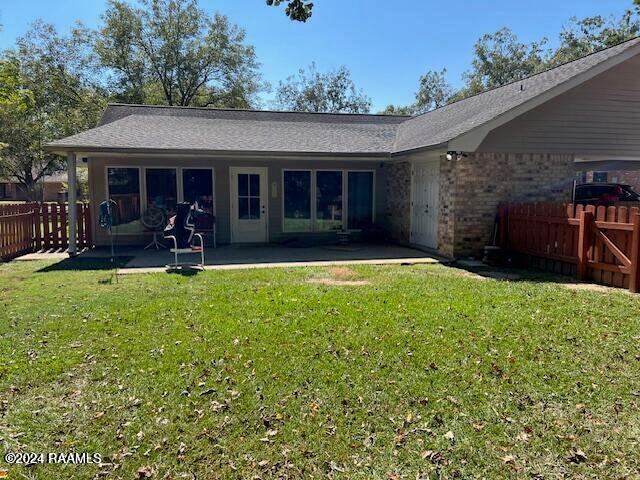 rear view of property featuring a lawn and a patio