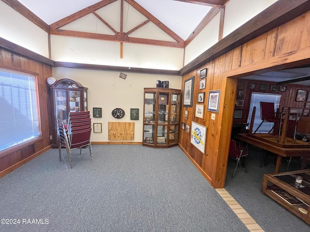 sitting room featuring carpet, lofted ceiling with beams, and wooden walls