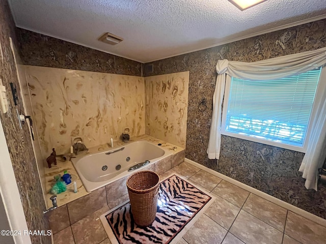 bathroom with tile patterned floors, a tub to relax in, and a textured ceiling