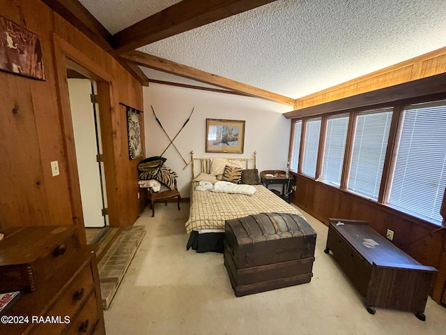 bedroom featuring beamed ceiling, a textured ceiling, and wooden walls