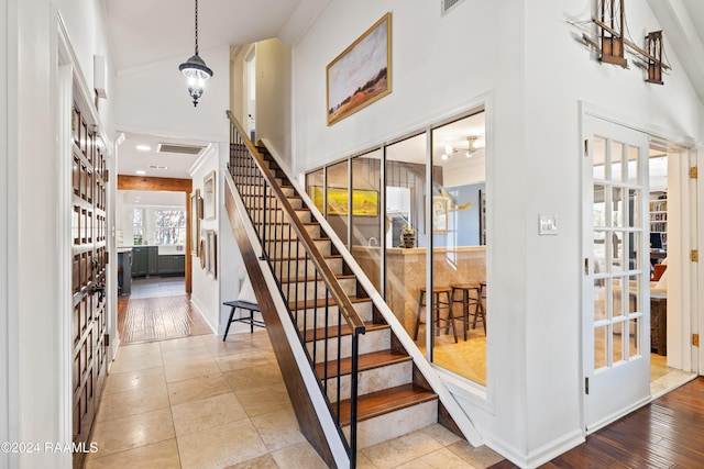 staircase featuring hardwood / wood-style floors and a high ceiling