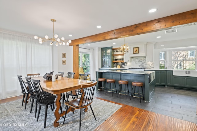 dining room with beamed ceiling, plenty of natural light, dark wood-type flooring, and a notable chandelier