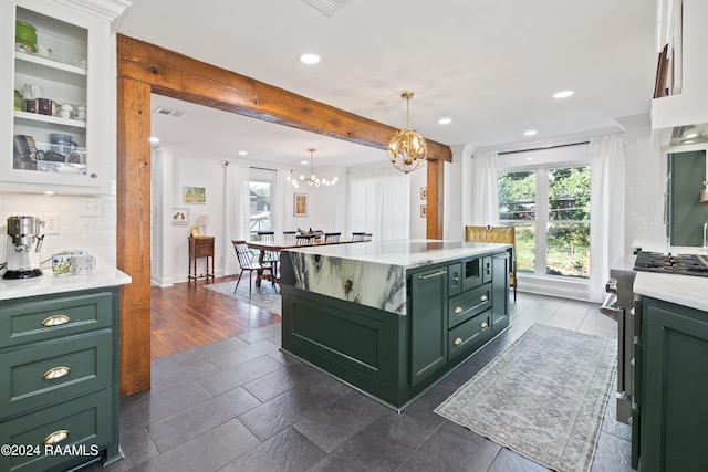 kitchen with a center island, dark wood-type flooring, green cabinets, tasteful backsplash, and decorative light fixtures