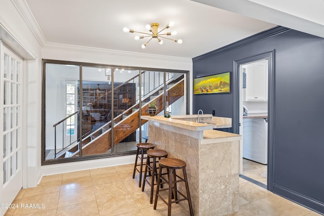 bar with crown molding, sink, and a notable chandelier