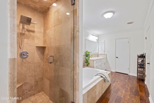 bathroom with hardwood / wood-style flooring, vanity, crown molding, and shower with separate bathtub