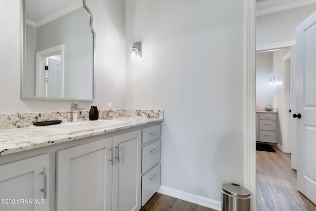 bathroom featuring hardwood / wood-style flooring, vanity, and ornamental molding