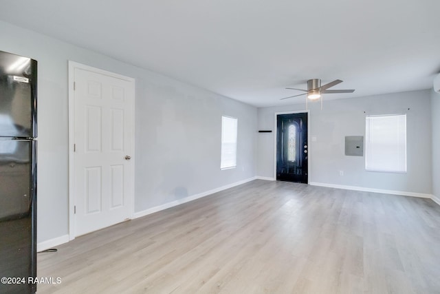 unfurnished room with light wood-type flooring, electric panel, and ceiling fan