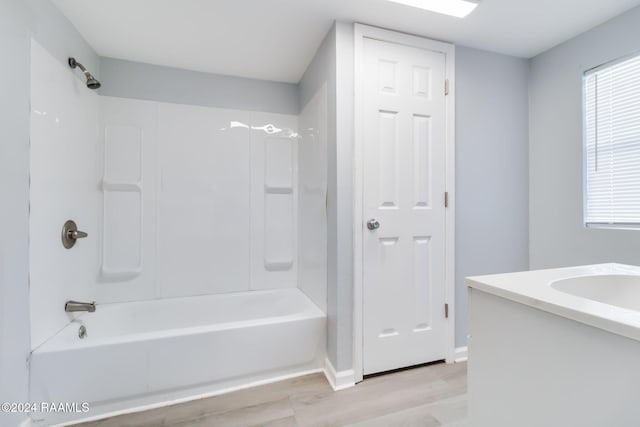 bathroom featuring hardwood / wood-style floors, vanity, and bathing tub / shower combination