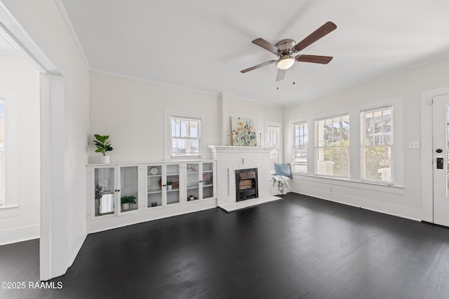 unfurnished living room with dark hardwood / wood-style floors, ceiling fan, crown molding, and a brick fireplace