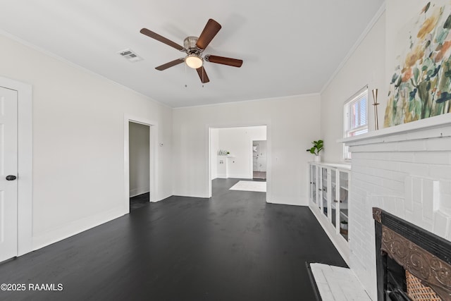 unfurnished living room with dark wood-type flooring, a brick fireplace, ceiling fan, and ornamental molding