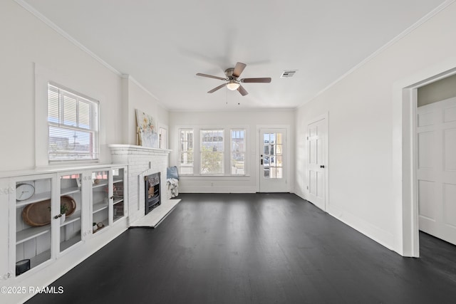 unfurnished living room with a fireplace, ceiling fan, crown molding, and dark wood-type flooring