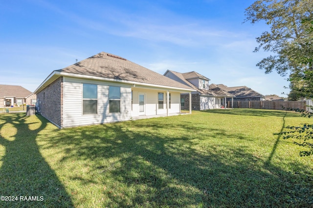 rear view of property with a yard