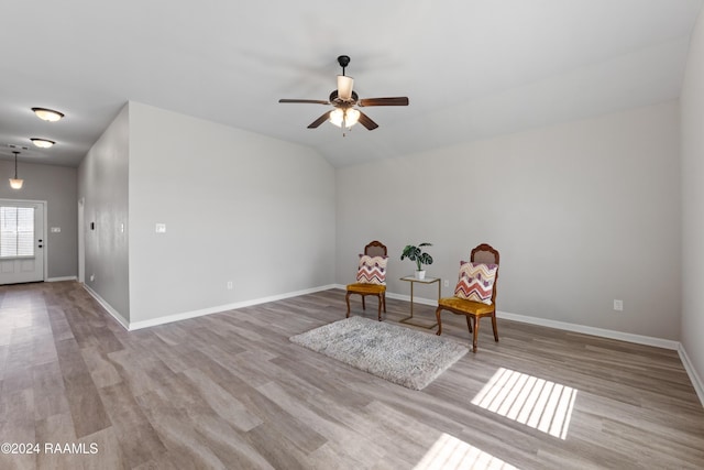 living area featuring light wood-type flooring, vaulted ceiling, and ceiling fan