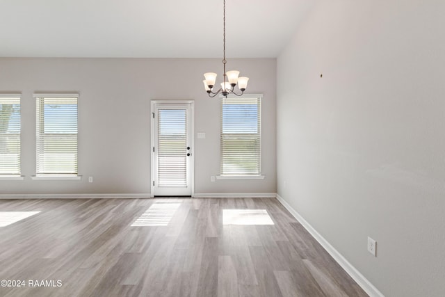 interior space featuring a notable chandelier, a healthy amount of sunlight, and wood-type flooring