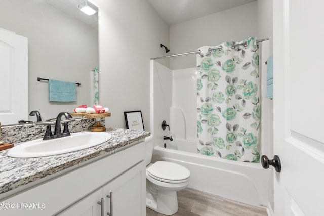 full bathroom featuring hardwood / wood-style flooring, vanity, toilet, and shower / bathtub combination with curtain