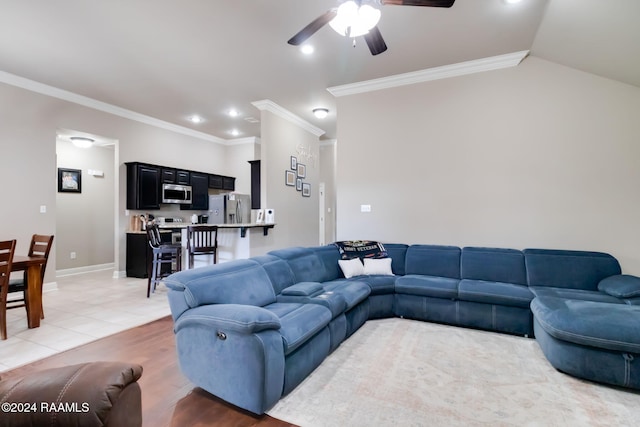 tiled living room with lofted ceiling, ceiling fan, and ornamental molding