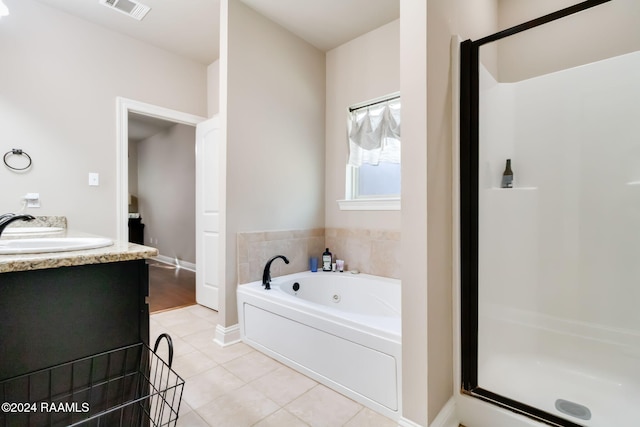 bathroom with tile patterned flooring, vanity, and independent shower and bath