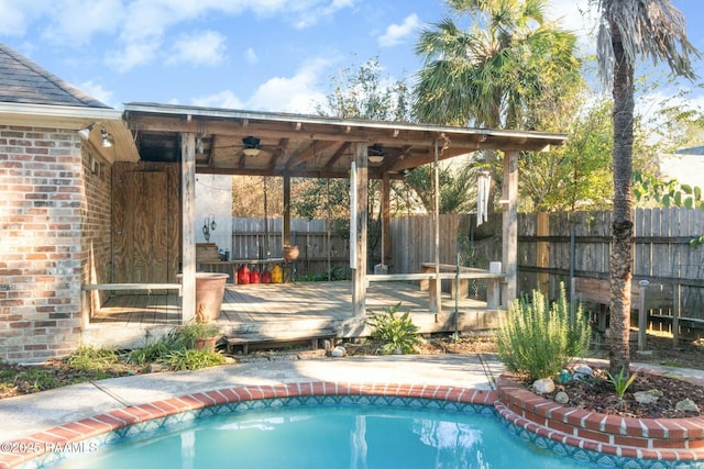 view of swimming pool featuring ceiling fan and a deck