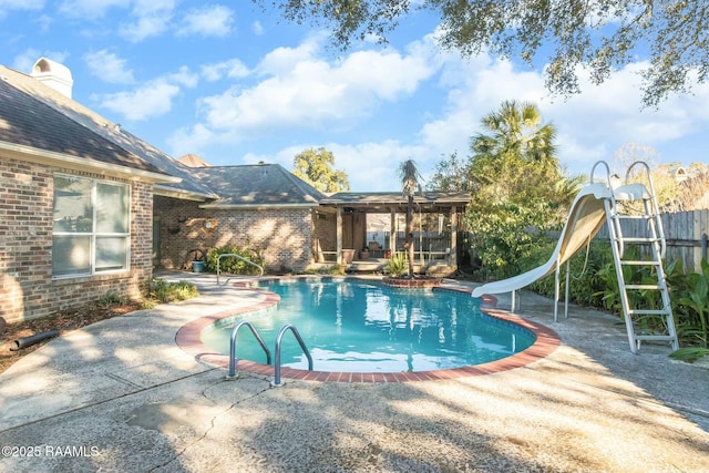 view of pool with a water slide and a patio