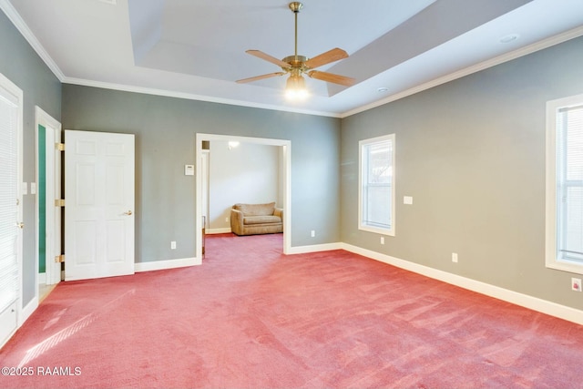 unfurnished bedroom featuring carpet, ceiling fan, crown molding, and a tray ceiling