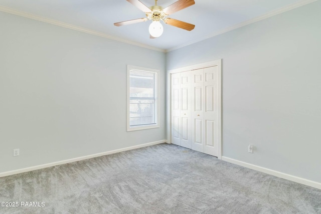 unfurnished bedroom featuring ornamental molding, a closet, ceiling fan, and light colored carpet