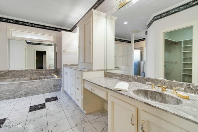 bathroom featuring vanity, a relaxing tiled tub, and ornamental molding