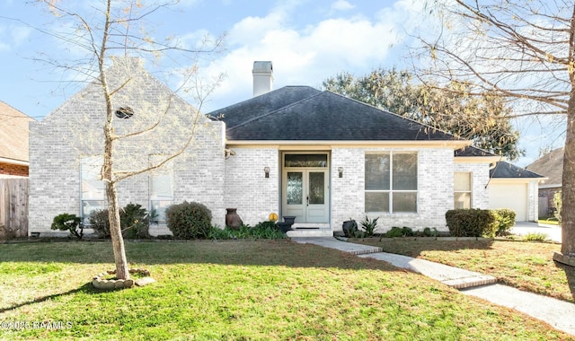 view of front of property with french doors, a front yard, and a garage