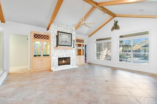 unfurnished living room with ceiling fan, beam ceiling, light tile patterned flooring, and a fireplace