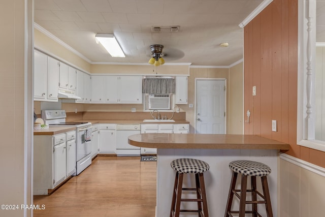 903 S Shireview Cir, Abbeville, LA 70510 - kitchen with white appliances, a peninsula, under cabinet range hood, a breakfast bar, and white cabinetry