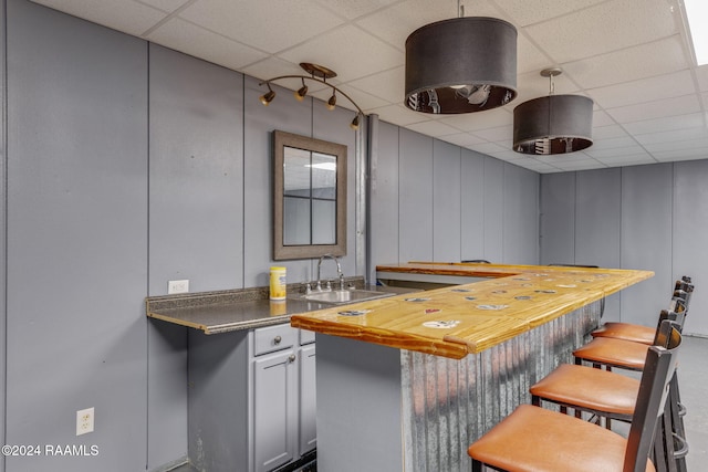 903 S Shireview Cir, Abbeville, LA 70510 - kitchen featuring a paneled ceiling, a kitchen bar, and a decorative wall