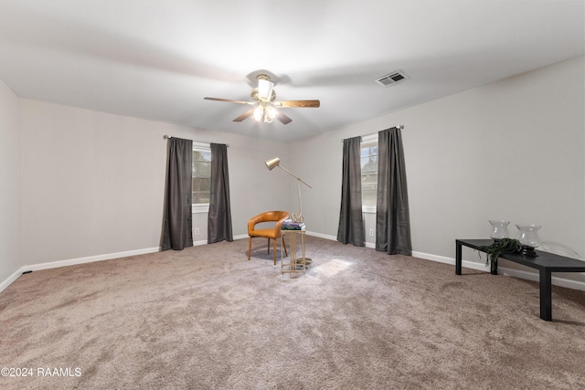 living area featuring carpet and ceiling fan