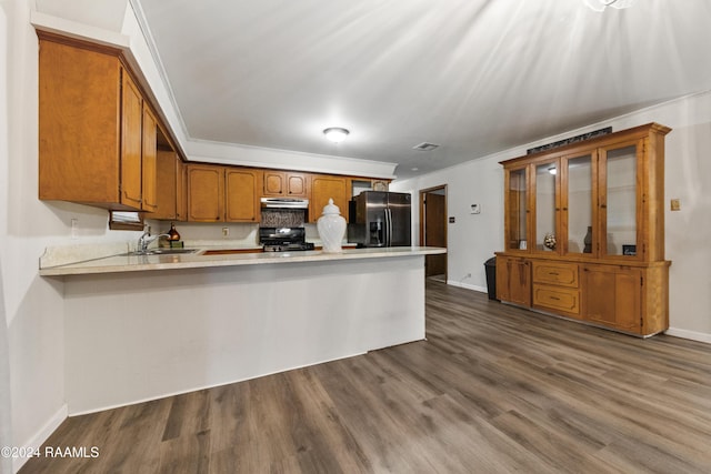 kitchen featuring black appliances, dark hardwood / wood-style flooring, kitchen peninsula, and sink