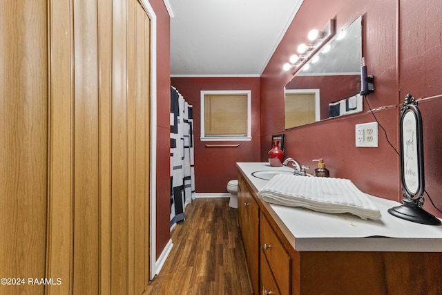 bathroom featuring crown molding, hardwood / wood-style floors, vanity, and toilet