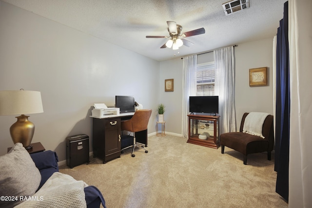 office space with ceiling fan, light colored carpet, and a textured ceiling