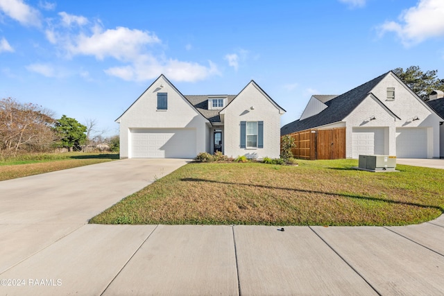 french country inspired facade with central AC, a front lawn, and a garage