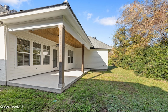 rear view of house with a patio area, ceiling fan, and a yard