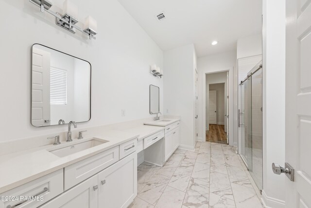 bathroom featuring vanity and a shower with door