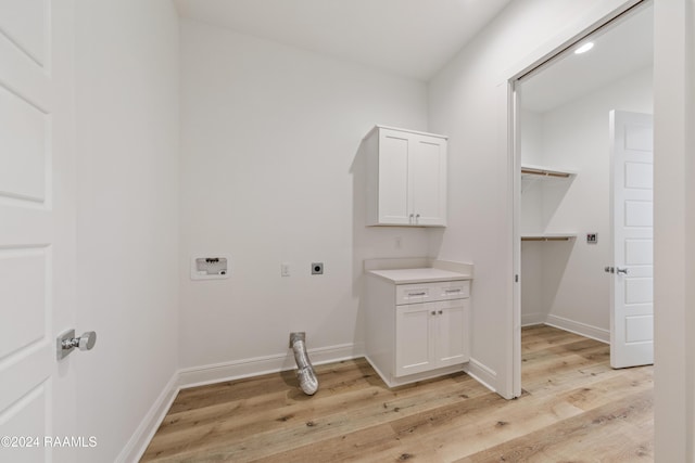 laundry room featuring hookup for an electric dryer, hookup for a washing machine, light hardwood / wood-style floors, and cabinets