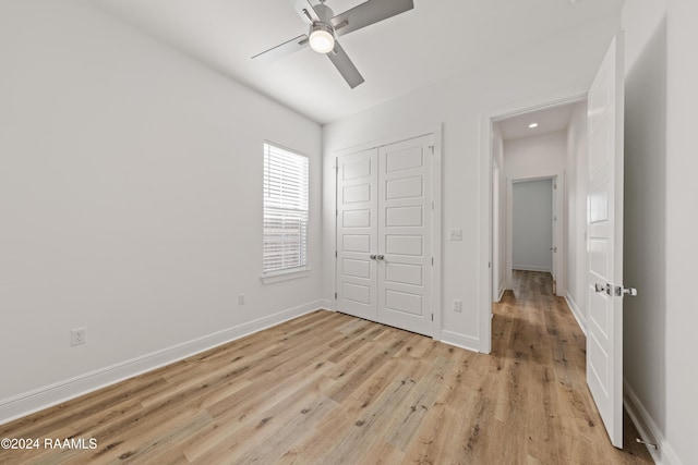 unfurnished bedroom with a closet, light hardwood / wood-style floors, and ceiling fan