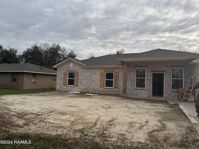 back of property with brick siding and a shingled roof