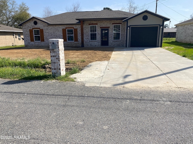 ranch-style home featuring driveway, brick siding, roof with shingles, and an attached garage